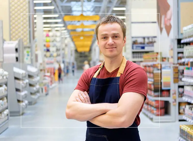 A man in an apron standing with his arms crossed.