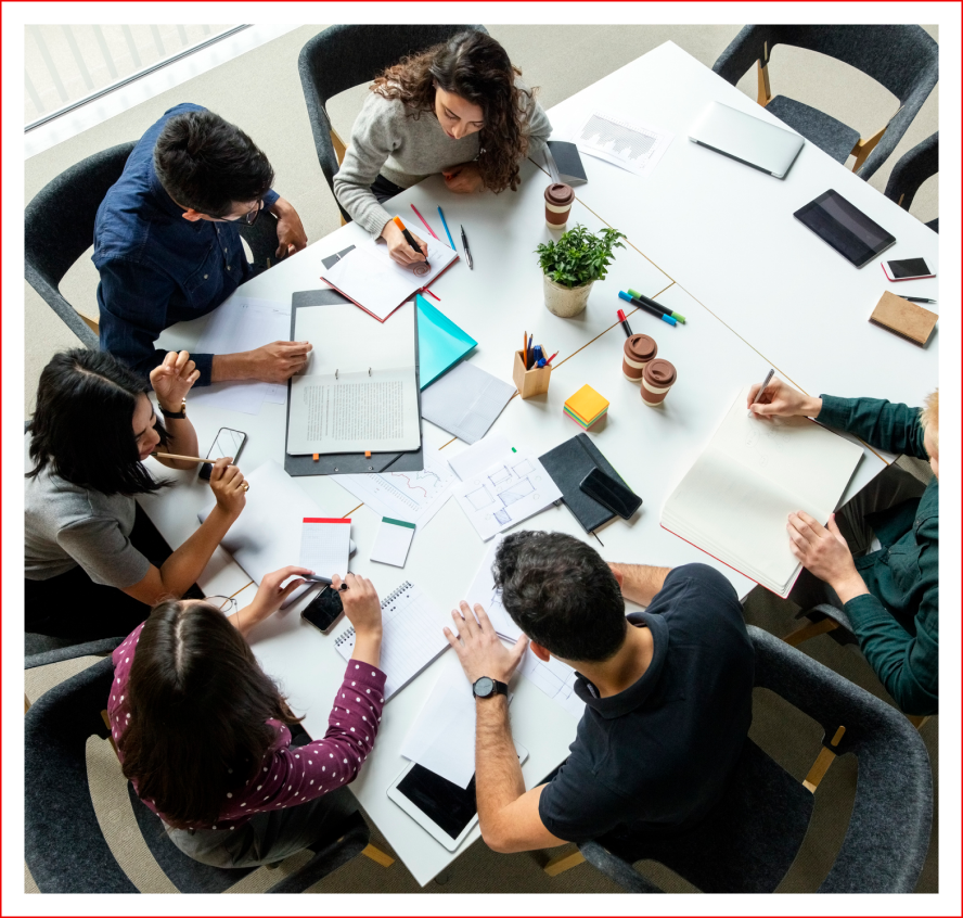 Team collaborating around a table with documents.